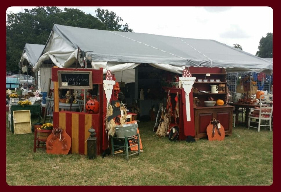 An antique market stall with cider, pumpkins and fall decorations