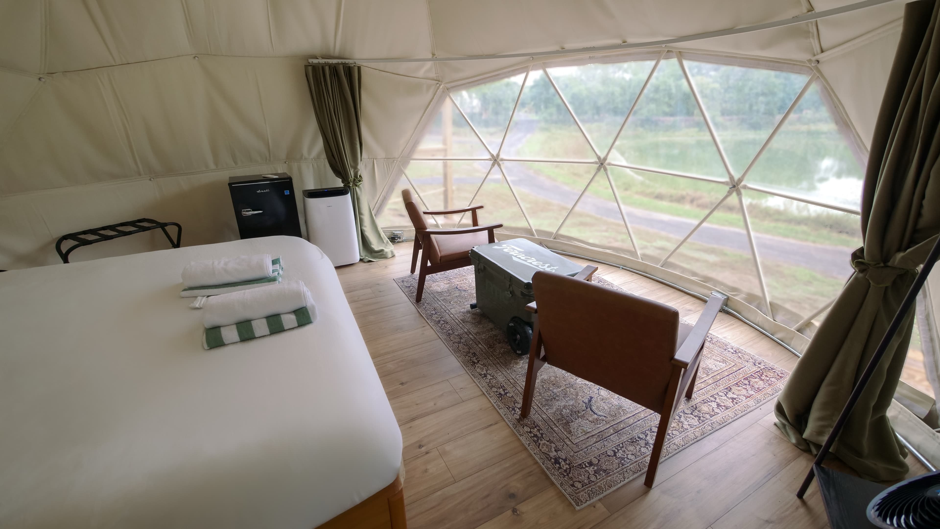 The king bed and window seating of a Classic Dome at Ferncrest Elkhorn River