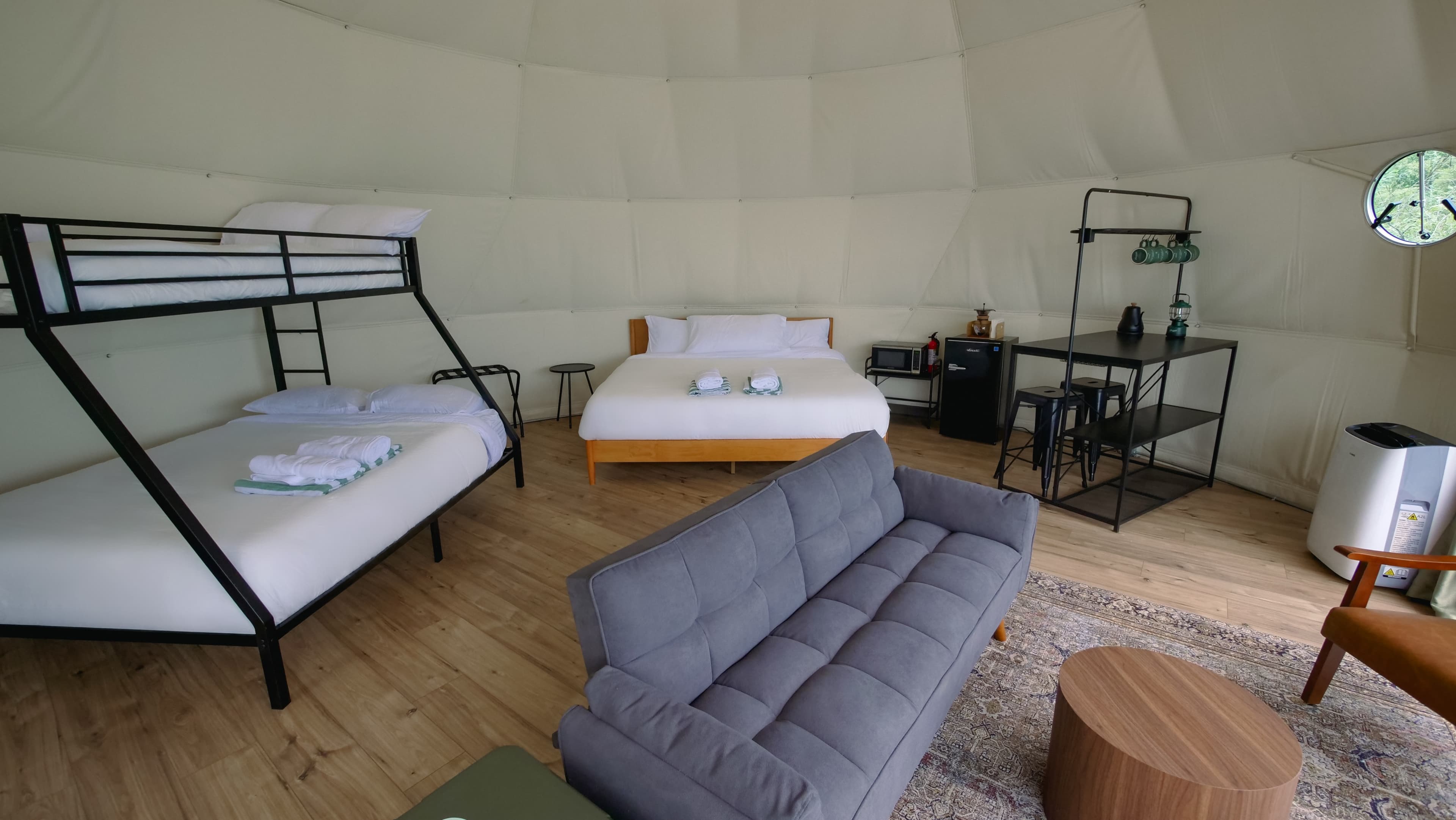 Bunk beds, a king bed and a futon sofa inside a Family Dome at Ferncrest Elkhorn River